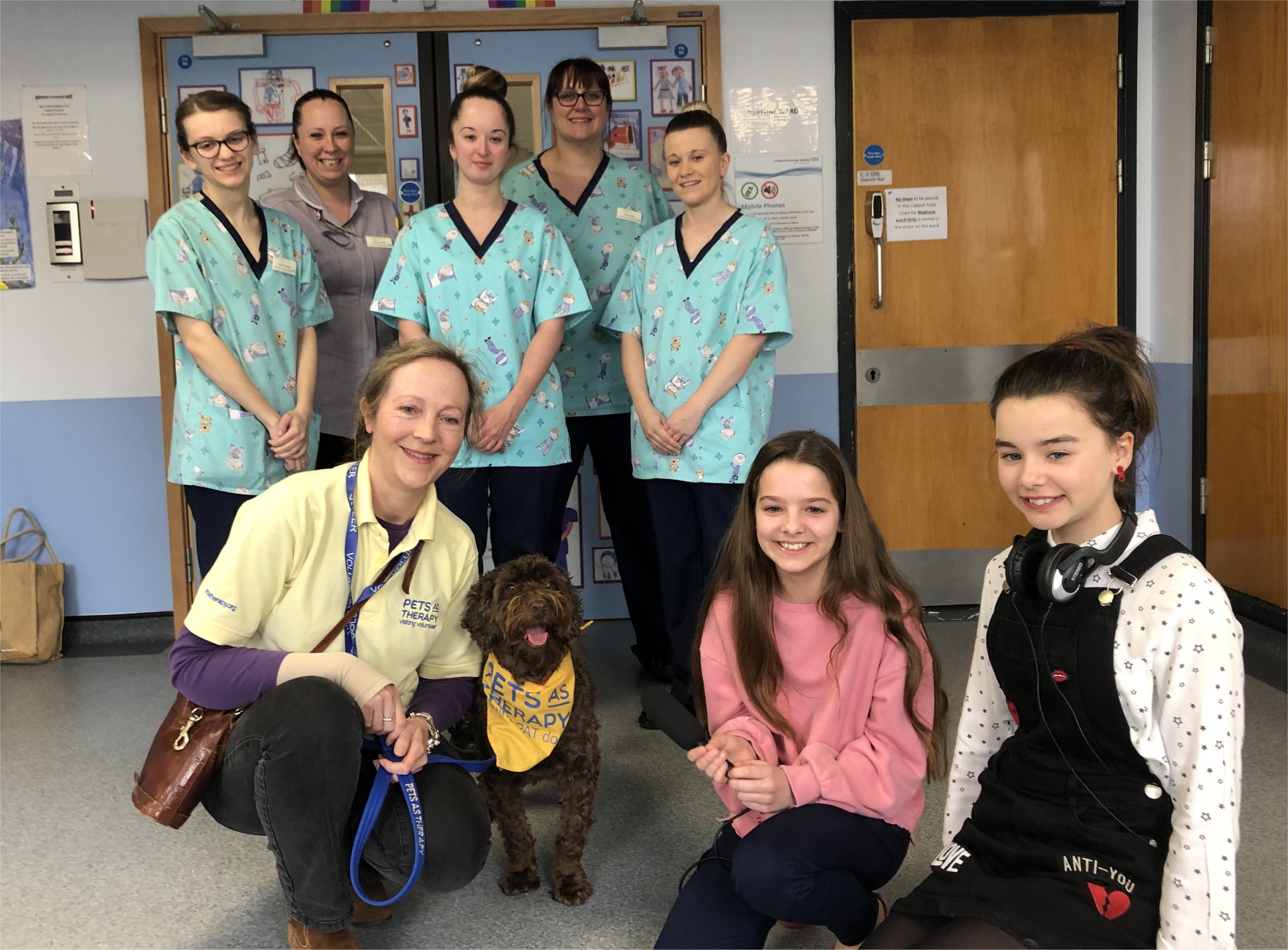 Kids presenters at Neptune Ward with staff and Rolo the Pets As Therapy dog
